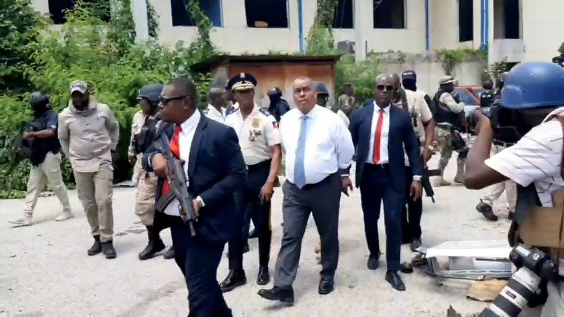 Haiti Prime Minister Garry Conille (center, white shirt) toured the site of the country’s largest public hospital on Tuesday, July 9, 2024, alongside Haiti National Police Chief Rameau Normil, left. The visit occurred a day after Normil announced police had taken back control of the site of the Hospital of the State University of Haiti, also known as the General Hospital, from armed gangs after months of attacks in the area. Normil made the announcement during the first joint press conference he held with the head of the Kenya-led Multinational Security Support mission, Godfrey Otunge.