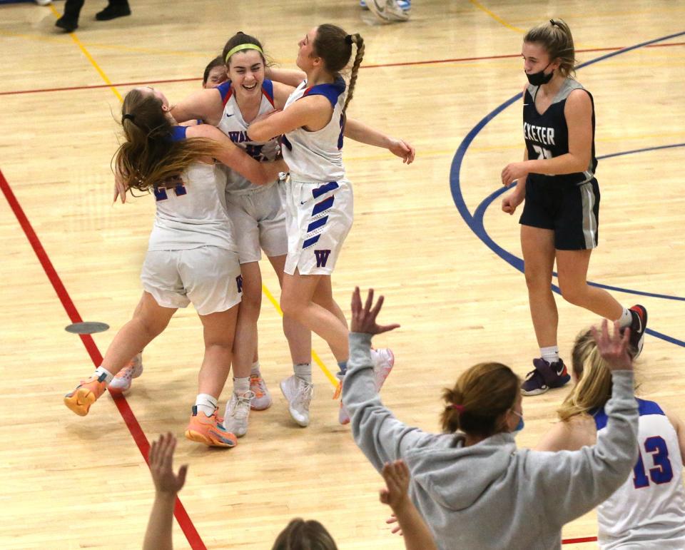 Winnacunnet's Abby Wilber gets hugged by teammates after her buzzer-beating halfcourt 3-point basket gave the Warriors a 42-40 win over Exeter Friday, Jan. 21, 2022.