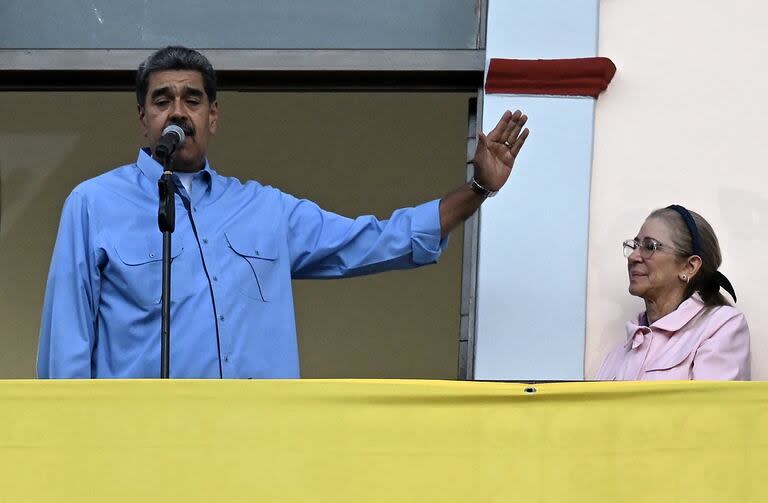 El presidente Nicolás Maduro, junto a la primera dama Cilia Flores, en el balcón del Palacio de Miraflores, en Caracas. (RAUL ARBOLEDA / AFP)