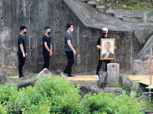 Stanley's four sons were seen escorting the coffin to the cemetery with eldest son Lawrence holding a framed photograph of their late father