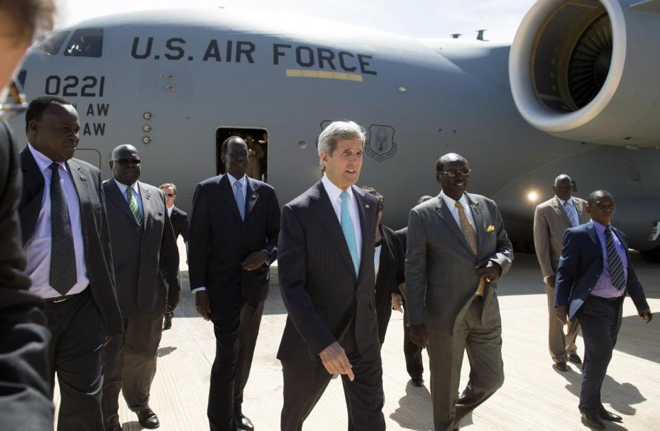 U.S. Secretary of State John Kerry, center, walks upon his arrival aboard a U.S. military airplane at Juba International Airport in Juba, South Sudan, Friday, May 2, 2014. Kerry is urging South Sudan's warring government and rebel leaders to uphold a monthslong promise to embrace a cease-fire or risk the specter of genocide through continued ethnic killings. (AP Photo/Saul Loeb, Pool)