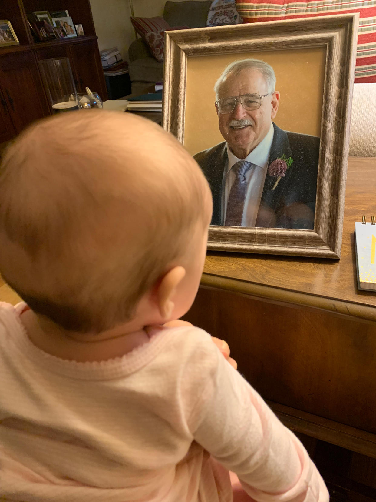 My daughter staring at a photo of my dad. (Courtesy Leah Rocketto)