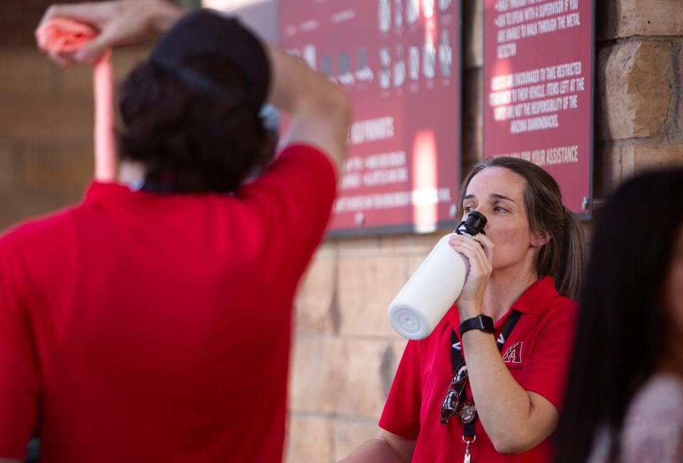 Jul 19, 2023; Phoenix, AZ, USA; Employees drink water and find shelter in the shade ahead of the Moran Wallen concert at the Chase Field on Wednesday, July 19, 2023.