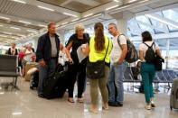 Passengers are seen at Thomas Cook check-in points at Mallorca Airport as an announcement is expected on the tour operator, in Palma de Mallorca