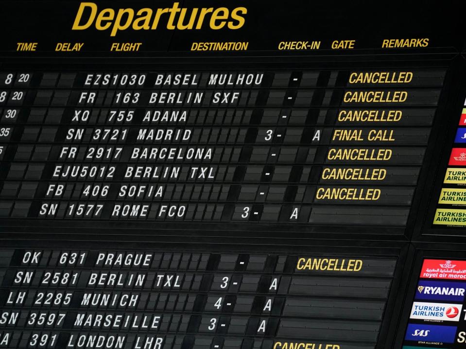 An airport departures board showing canceled flights.