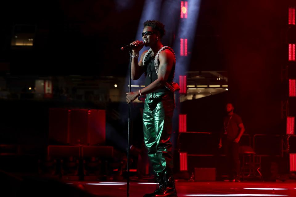 Lucky Daye performing in green metallic pants and a black shirt