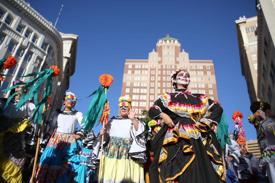 Women in colorful costumes parade through Downtown El Paso on Oct. 23, 2021, in celebration of Día de los Muertos.