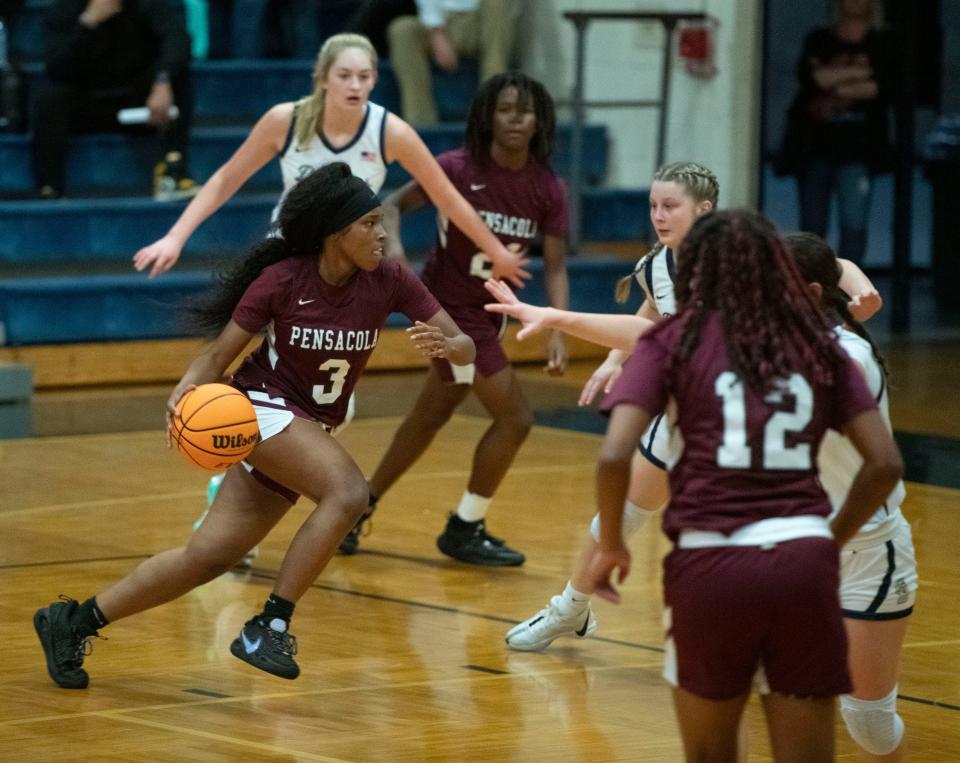 Pensacola High School's Erica McCray (No. 3) drives to the boards against the Gulf Breeze defense during the Dolphin's home game against the visiting Tigers on Friday, Jan. 5, 2024.