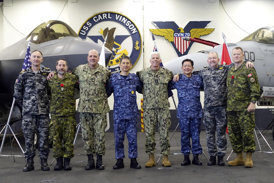 Navy officials from the four main participants of the Annualex 23 joint exercise pose for a group photo after a news conference aboard a U.S. Navy aircraft carrier USS Carl Vinson, Saturday, Nov. 11, 2023, as they stressed the importance of reinforcing joint response capability and operability to protect the peace and stability in the Indo-Pacific. (AP Photo/Mari Yamaguchi).