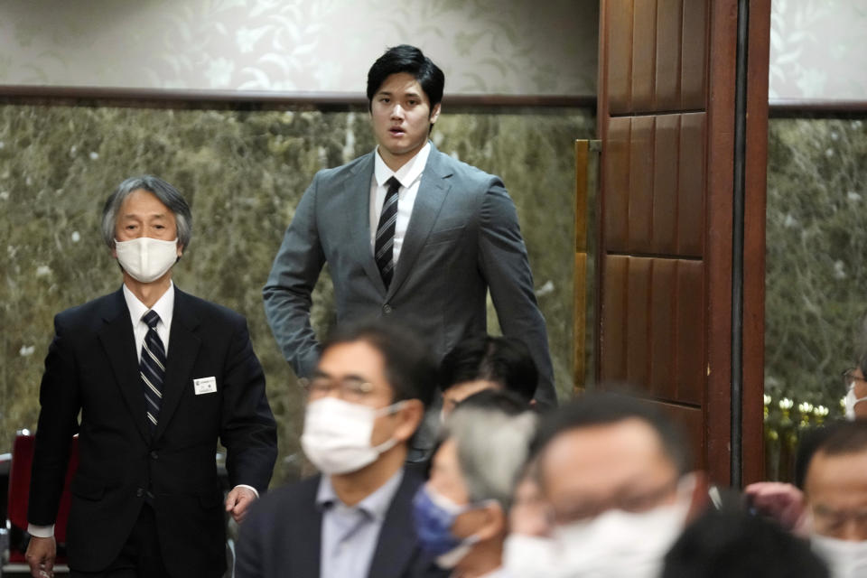 Los Angeles Angels' Shohei Ohtani is escorted to attend a press conference at the Japan National Press Club Monday, Nov. 15, 2021, in Tokyo. (AP Photo/Eugene Hoshiko)