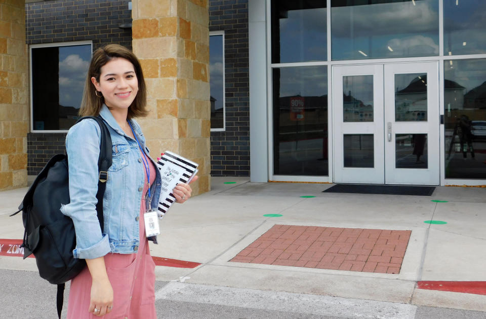 First-year teacher Cindy Hipps stands outside of Lagos Elementary School, at Manor Independent School District campus east of Austin, Texas where she has taught first grade in a virtual and in-person hybrid classroom during the COVID-19 pandemic. Hipps said she was told she "was introduced to the ring of fire of teaching." "I feel like a superwoman now, like I can take on anything.” (Acacia Coronado/Report for America via AP)