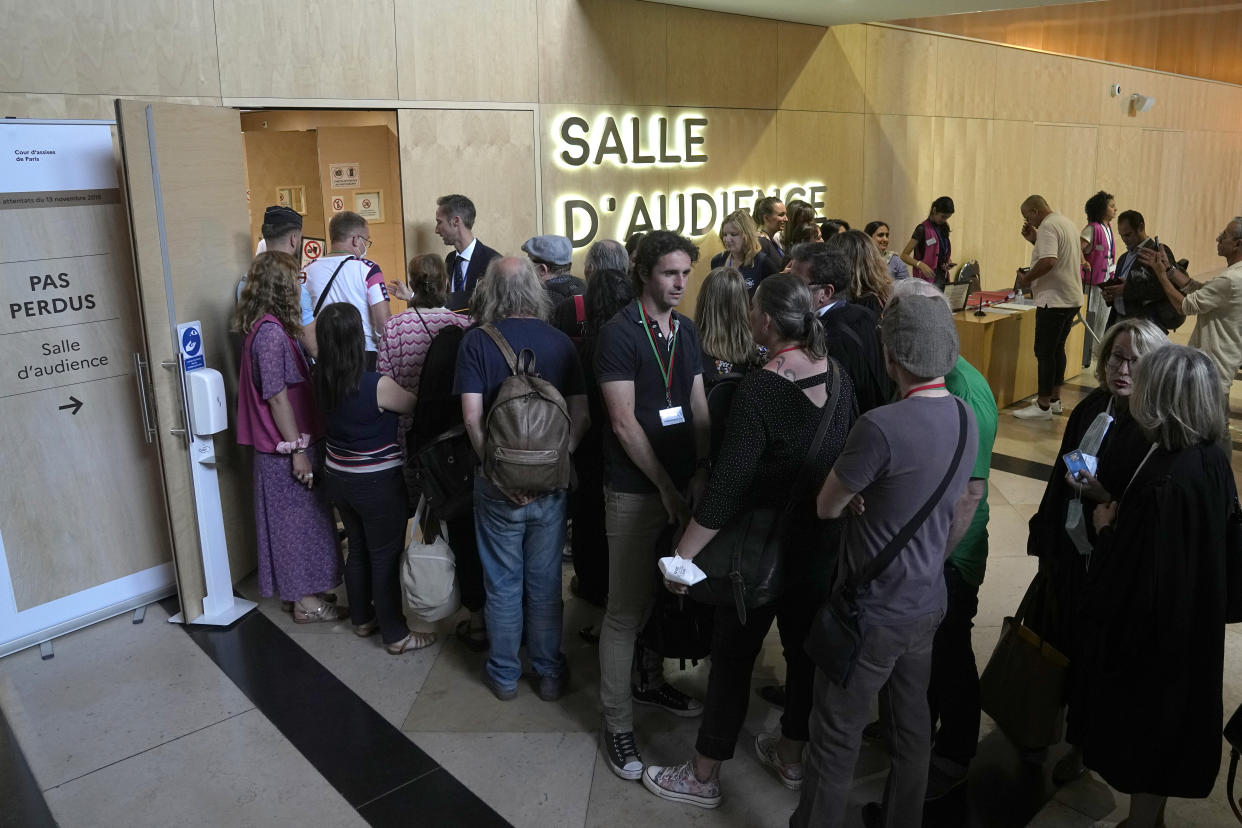 Lawyers and other people queue outide the special court room Wednesday, June 29, 2022 in Paris. The lone survivor of the Islamic State extremist team that attacked Paris in 2015 has proclaimed his radicalism, wept, apologized to victims and pleaded with judges to forgive his "mistakes." For victims' families and survivors of the attacks, the trial for Salah Abdeslam and suspected accomplices has been excruciating yet crucial in their quest for justice and closure. The court will hand down its verdict Wednesday. (AP Photo/Michel Euler)