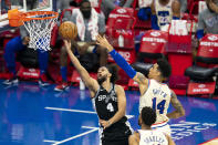 San Antonio Spurs' Derrick White, left, goes up to shoot against Philadelphia 76ers' Danny Green, right, during the first half of an NBA basketball game, Sunday, March 14, 2021, in Philadelphia. (AP Photo/Chris Szagola)