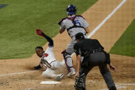 Atlanta Braves' Ozzie Albies scores past Los Angeles Dodgers catcher Austin Barnes on a double by Dansby Swanson during the sixth inning in Game 4 of a baseball National League Championship Thursday, Oct. 15, 2020, in Arlington, Texas. (AP Photo/Eric Gay)