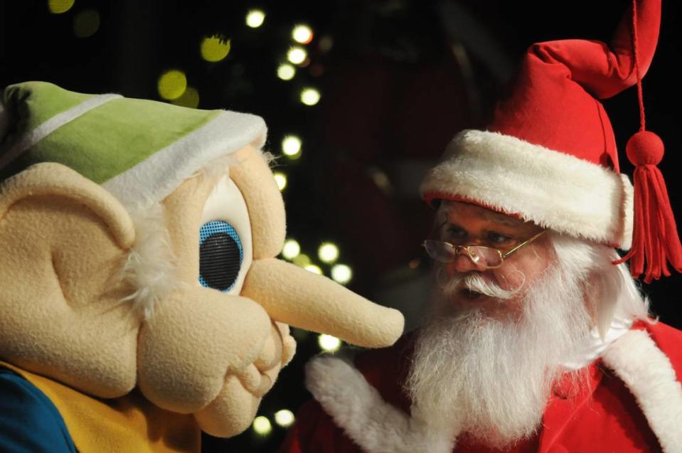 Santa talks to a Vernon Grant gnone during the opening ceremony of ChristmasVille.