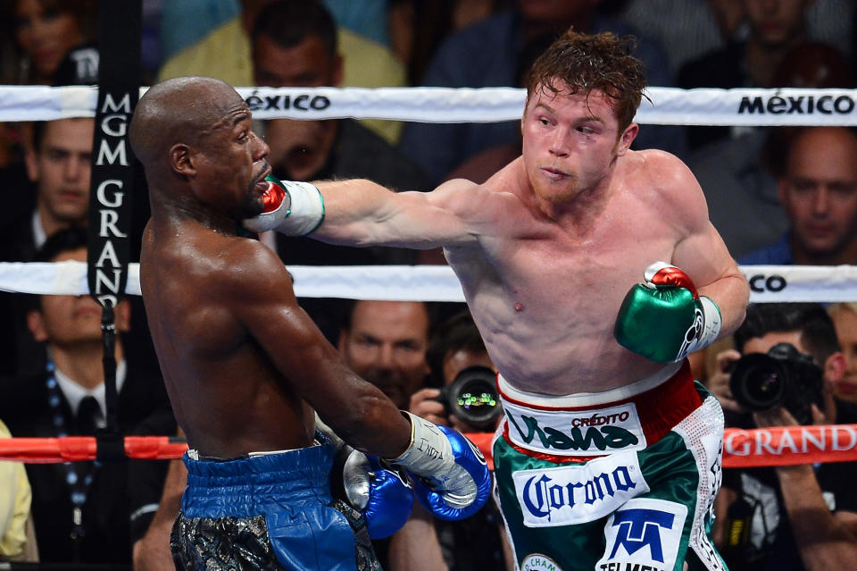 LAS VEGAS, NV - SEPTEMBER 14:  (R-L) Canelo Alvarez throws a right at Floyd Mayweather Jr. during their WBC/WBA 154-pound title fight at the MGM Grand Garden Arena on September 14, 2013 in Las Vegas, Nevada.  (Photo by Ethan Miller/Getty Images)