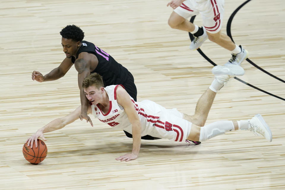 Wisconsin's Tyler Wahl (5) and Penn State's Izaiah Brockington (12) dive for a loose ball during the second half of an NCAA college basketball game at the Big Ten Conference tournament, Thursday, March 11, 2021, in Indianapolis. (AP Photo/Darron Cummings)