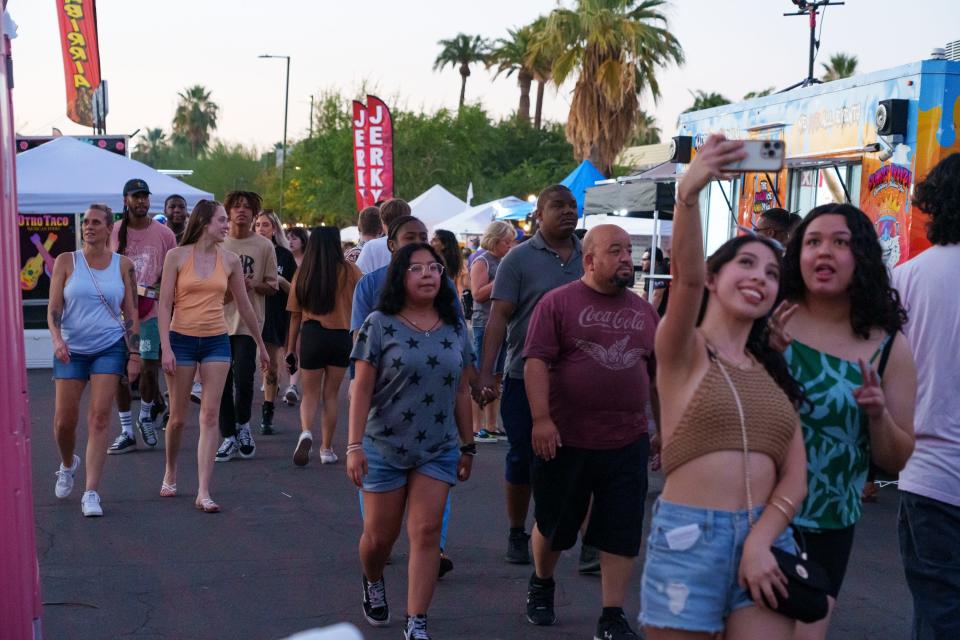 People crowd the streets of Downtown Phoenix, near Roosevelt Row for the First Friday Artwalk on August 4, 2023.