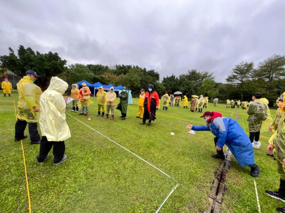 中華民國高智爾運動協會昨於板樹體育館舉辦高智爾球聯誼賽，球友們穿著雨衣雨鞋進行比賽。（中華民國高智爾運動協會提供）