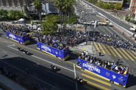 Buses carrying Los Angeles Rams players and coaches drive past fans during the team's victory parade in Los Angeles, Wednesday, Feb. 16, 2022, following their win Sunday over the Cincinnati Bengals in the NFL Super Bowl 56 football game. (AP Photo/Kyusung Gong)