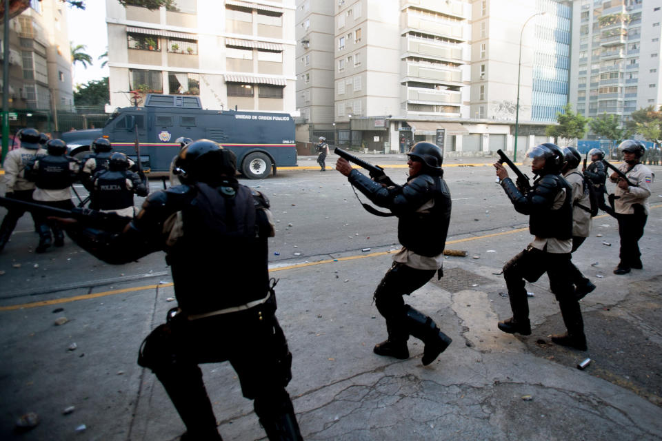 Bolivarian National Police fire tear gas toward opposition demonstrators in Caracas, Venezuela, Saturday, Feb. 15, 2014. Venezuelan security forces backed by water tanks and tear gas dispersed groups of anti-government demonstrators who tried to block Caracas' main highway Saturday evening. (AP Photo/Alejandro Cegarra)