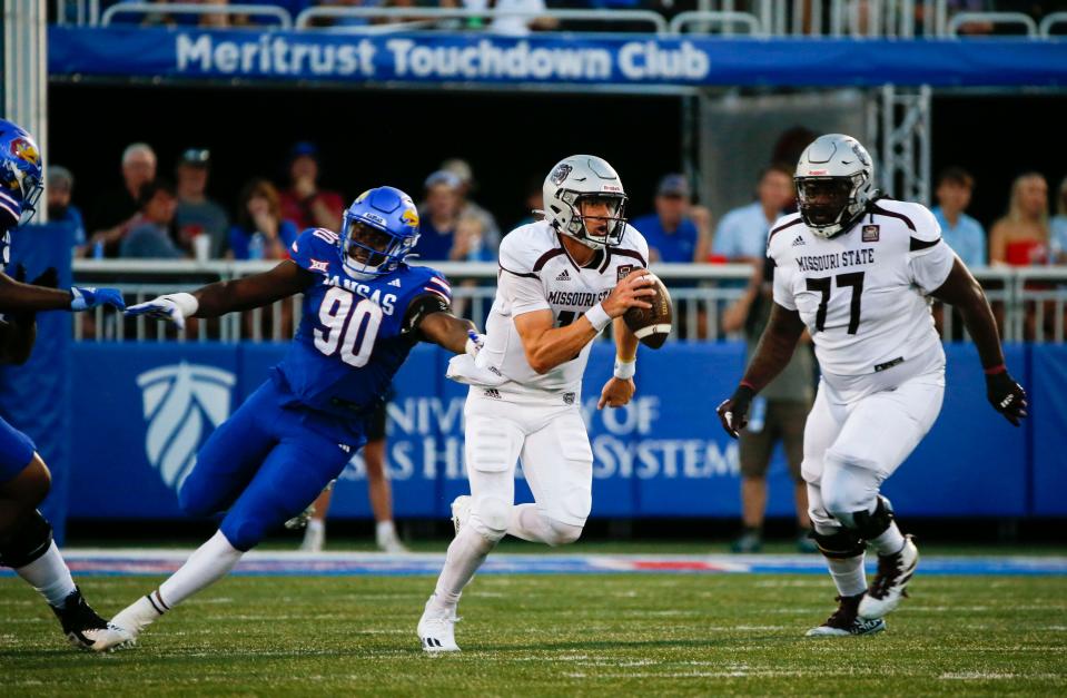 Missouri State's Jacob Clark (12) avoids a sack by Kansas' Jereme Robinson (90) as the Bears take on the University of Kansas Jayhawks at David Booth Kansas Memorial Stadium in Lawrence Kansas on Friday, Sept. 1, 2023.