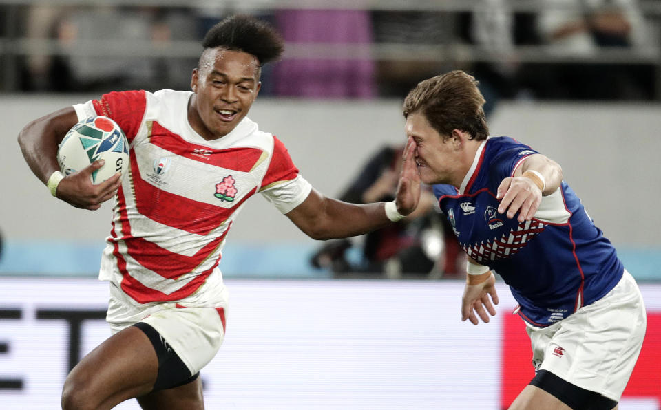 Japan's Kotaro Matsushima, left, fends off Russia's Vladislav Sozonov to score his third try during the Rugby World Cup Pool A game at Tokyo Stadium between Russia and Japan in Tokyo, Japan, Friday, Sept. 20, 2019. (AP Photo/Jae Hong)