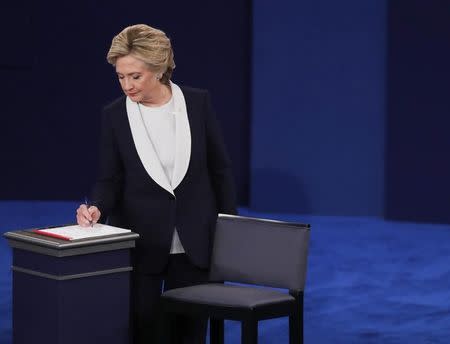 Democratic U.S. presidential nominee Hillary Clinton takes notes during her presidential town hall debate against Republican U.S. presidential nominee Donald Trump (not shown) at Washington University in St. Louis, Missouri, U.S., October 9, 2016. REUTERS/Jim Young