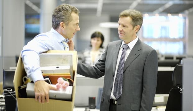 Businessman leaving office with box of personal items