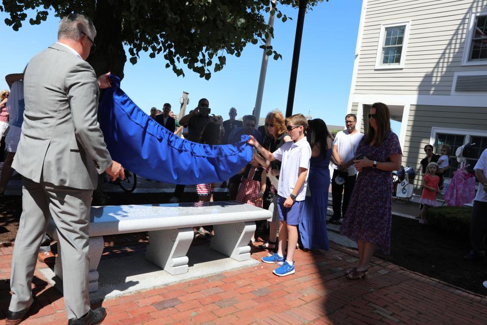 Michael Norton and Michael Norton Jr. unveil the bench Mayor Thomas Koch and the City of Quincy dedicated to the late Larry Norton.