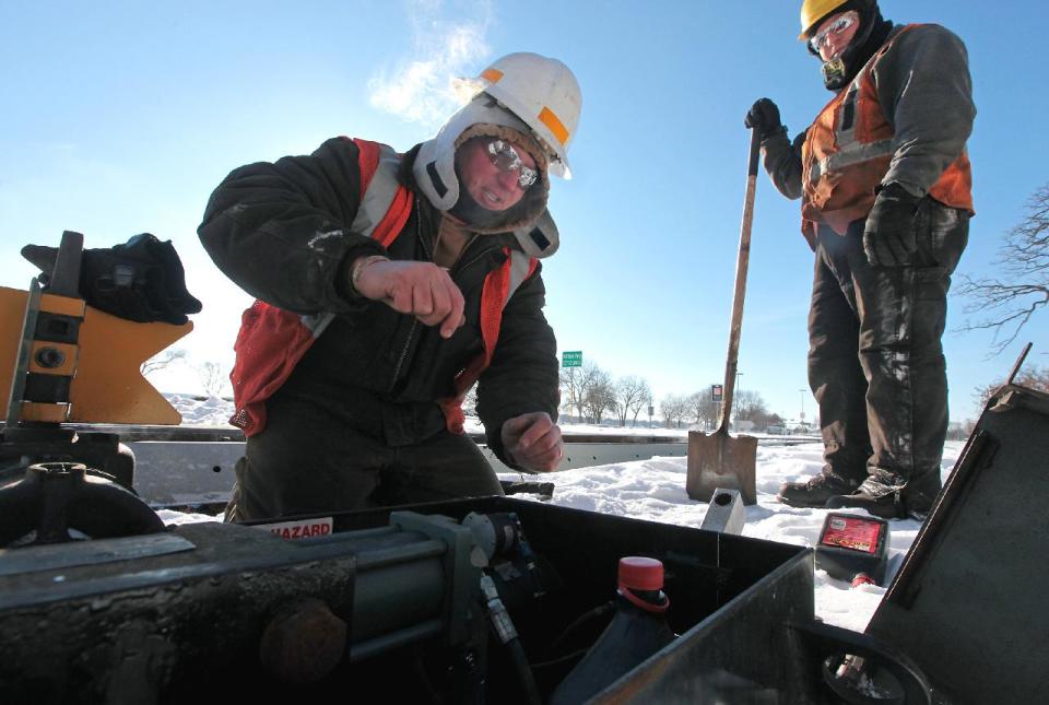 Wisconsin and Southern Railway workers Stacey Hurda, left, and Brady Whipple work to thaw a frozen power switch which controls a track changeout in Madison, Wis., Monday, Jan. 6, 2014. (AP Photo/Wisconsin State Journal, John Hart)