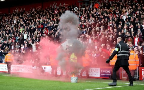 A flare is thrown from the stands - Credit: PA