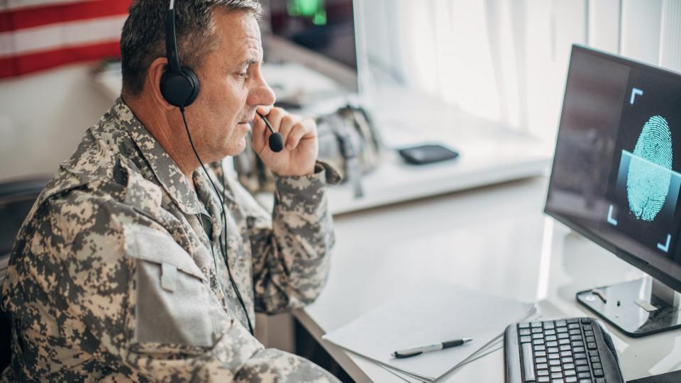 Army solider working in the office and writing on some papers.