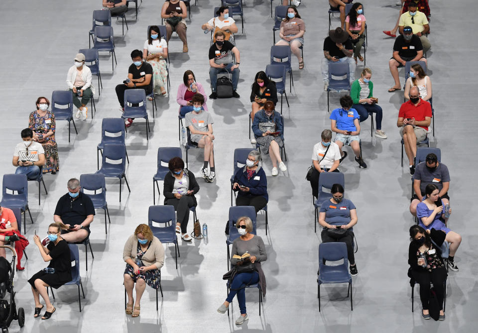 People are seen in the post vaccination observation area after receiving their Covid-19 vaccination in Brisbane. Source: AAP