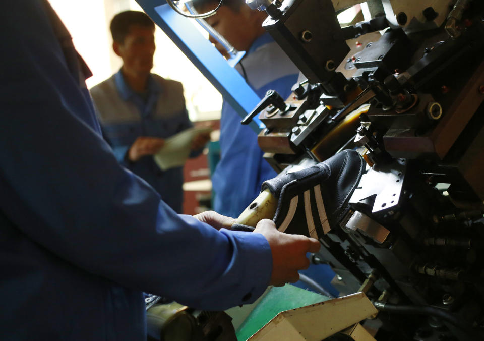 In this Friday, Feb. 1, 2019, photo, workers make sneakers at the Ryuwon Shoe Factory that specializes in sports footwear, in Pyongyang, North Korea. North Korean pop culture, long dismissed by critics as a kitschy throwback to the dark days of Stalinism, is getting a major upgrade under leader Kim Jong Un. The changes are being seen in everything from television dramas and animation programs to the variety and packaging of consumer goods, which have improved significantly under Kim. (AP Photo/Dita Alangkara)