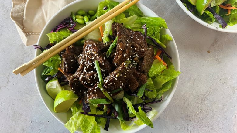 salad with asian beef and chopsticks