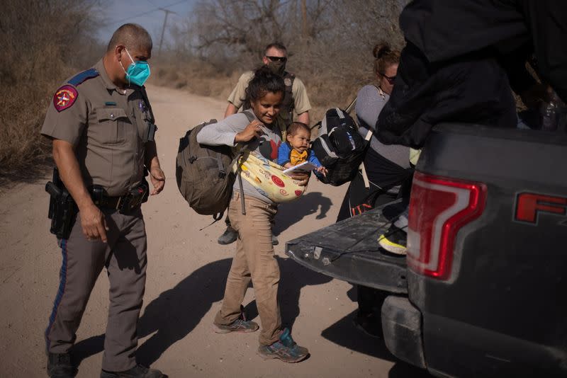 Migrant families get into truck for transport after crossing the Rio Grande River into thr U.S. from Mexico in Penitas, Texas