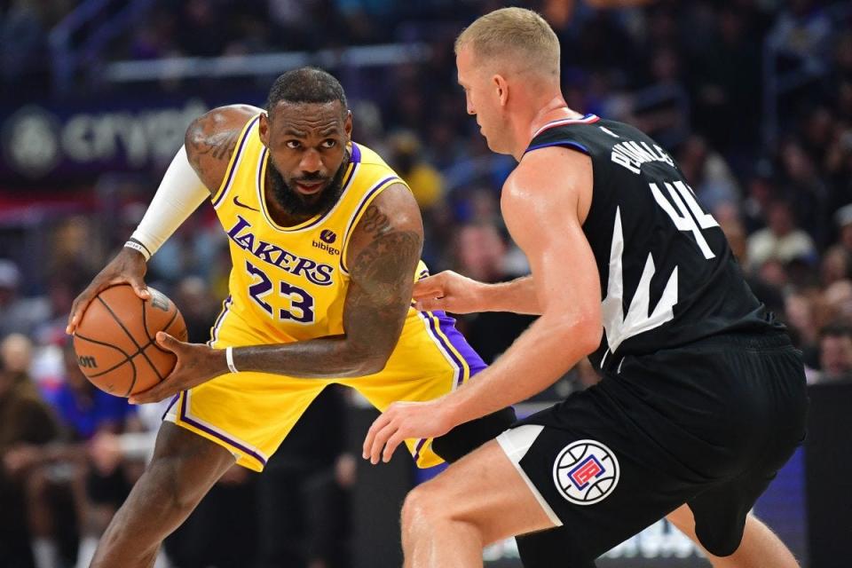 Feb 28, 2024; Los Angeles, California, USA; Los Angeles Lakers forward LeBron James (23) controls the ball against Los Angeles Clippers center Mason Plumlee (44) during the first half at Crypto.com Arena. Mandatory Credit: Gary A. Vasquez-USA TODAY Sports