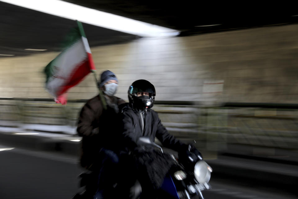 Iranians attend a rally marking the 42nd anniversary of the 1979 Islamic Revolution, in Tehran, Iran, Wednesday, Feb. 10, 2021. Iranians Wednesday began a vehicle-only rallies in cities and towns across the country to mark the anniversary of its 1979 Islamic Revolution. The decision for replacing traditional rallies and demonstrations by vehicle-only move came as a measure to prevent spread of the coronavirus as the country struggles to stem the worst outbreak of the pandemic in the Middle East with death toll nearing 59,000 and some 1.48 million confirmed cases of the virus. The country on Tuesday launched a coronavirus inoculation campaign. (AP Photo/Ebrahim Noroozi)