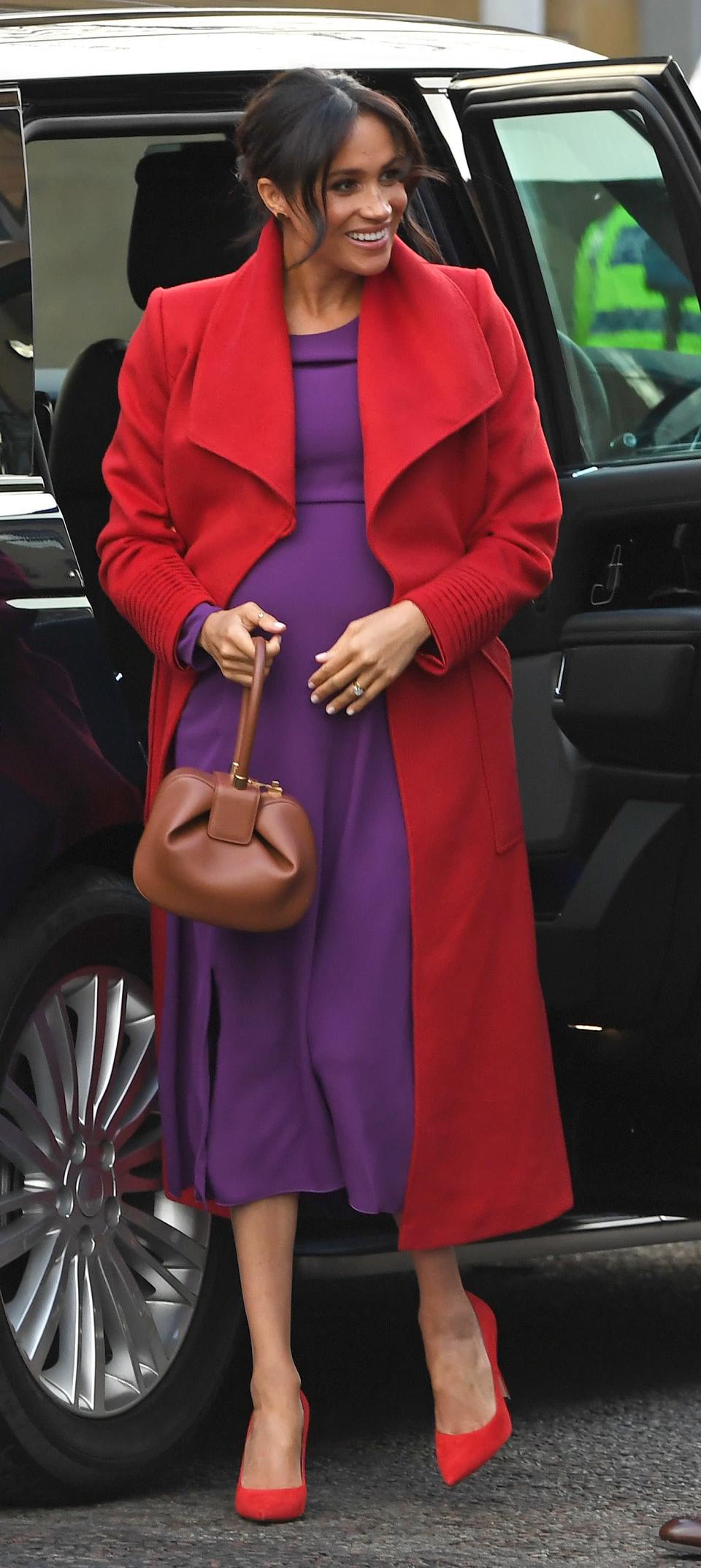 <p>For Harry and Meghan’s first joint engagement of 2019, the Duchess of Sussex broke her navy streak in a colour-blocking ensemble by her favourite Canadian labels. The royal dressed her bump in a traffic light red Sentaler coat teamed with a purple midi dress by Aritzia’s Babaton. Clashing Stuart Weitzman heels finished the look. <em>[Photo: Getty]</em> </p>