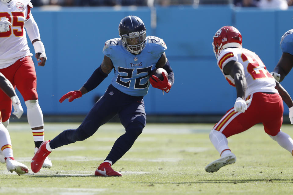 Tennessee Titans running back Derrick Henry (22) carries the ball as Kansas City Chiefs defensive back Rashad Fenton, right, blocks his path in the first half of an NFL football game Sunday, Oct. 24, 2021, in Nashville, Tenn. (AP Photo/Wade Payne)