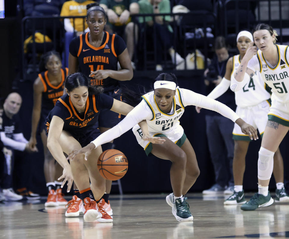 Baylor guard Ja'Mee Asberry, right, pulls in a loose ball over Oklahoma State guard Neferatali Notoa, left, in the second half of an NCAA college basketball game, Wednesday, Jan. 19, 2022, in Waco, Texas. (Rod Aydelotte/Waco Tribune-Herald via AP)