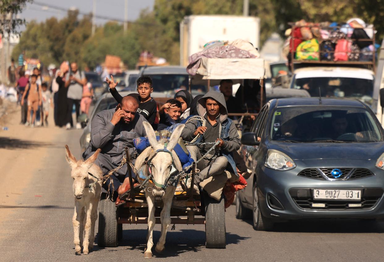 TOPSHOT - Riding a donkey drawn cart as family along with hundreds of other Palestinian carrying their belongings flee following the Israeli army's warning to leave their homes and move south before an expected ground offensive, in Gaza City on October 13, 2023. Palestinians carried belongings through the rubble-strewn streets of Gaza City on October 13, in search of refuge as Israel's army warned residents to flee immediately before an expected ground offensive in retaliation against Hamas for the deadliest attack in Israeli history. (Photo by MAHMUD HAMS / AFP) (Photo by MAHMUD HAMS/AFP via Getty Images)
