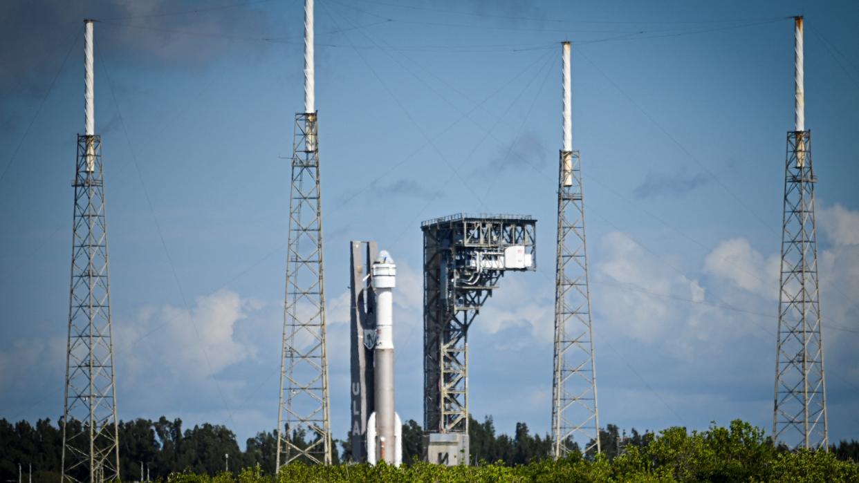  A rocket at a launch pad surrounded by towers. 