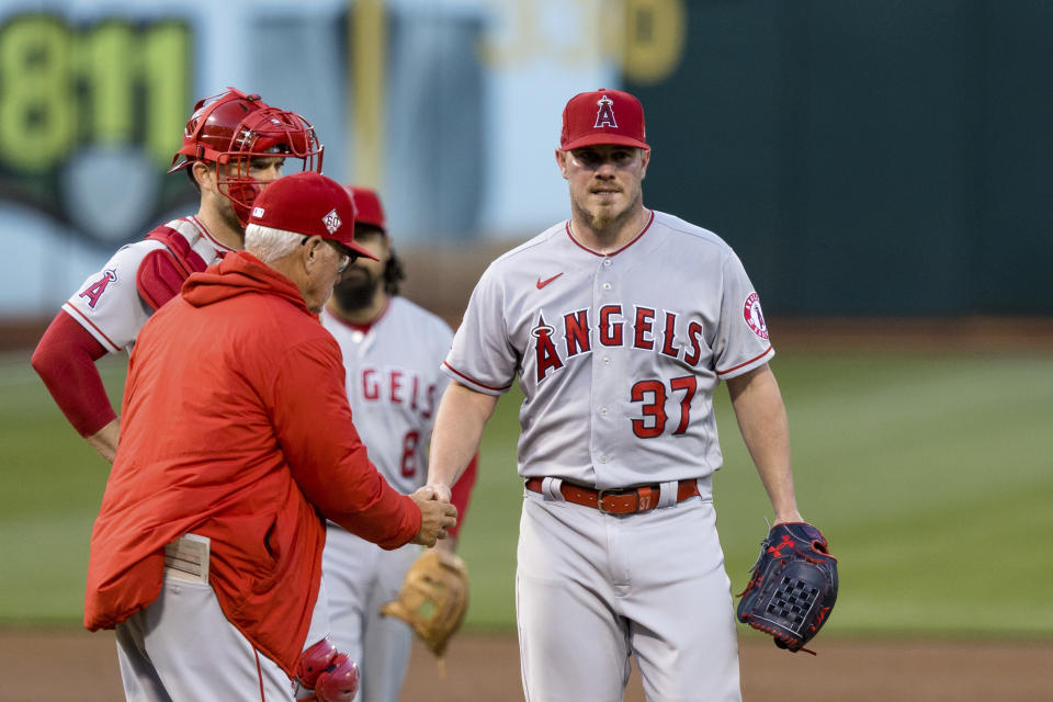 Los Angeles Angels starting pitcher Dylan Bundy (37) is relieved by manager Joe Maddon, left front, during the third inning of a baseball game against the Oakland Athletics in Oakland, Calif., Monday, June 14, 2021. (AP Photo/John Hefti)