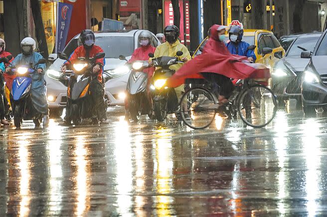 鋒面持續籠罩台灣，上月31日各地整日下著間歇大雨，台北市下班時間車燈在雨中將路面映得光輝燦爛。（黃子明攝）