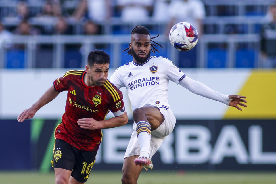 Seattle Sounders midfielder Nicolas Lodeiro, left, and LA Galaxy forward Raheem Edwards vie for the ball during the second half of an MLS soccer match in Carson, Calif., Saturday, April1, 2023. (AP Photo/Ringo H.W. Chiu)