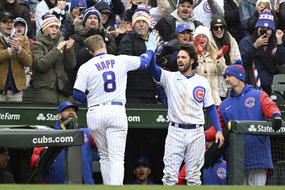 Chicago Cubs Ian Happ (8) is greeted by Dansby Swanson (7) after hitting a home run in the sixth inning of a baseball game against the Milwaukee Brewers, Saturday, April 1, 2023, in Chicago. (AP Photo/Quinn Harris)