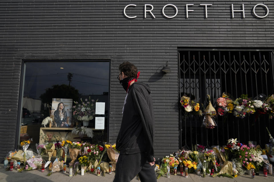 A man walks past flowers and candles that were placed outside Croft House store in honor of Brianna Kupfer on Tuesday, Jan. 18, 2022, in Los Angeles. The Los Angeles Police Department, West Bureau Homicide detectives are investigating the murder of Kupfer, a 24-year-old Pacific Palisades resident, who was killed at a business in the 300 block of North La Brea Avenue on Jan. 13. (AP Photo/Ashley Landis)