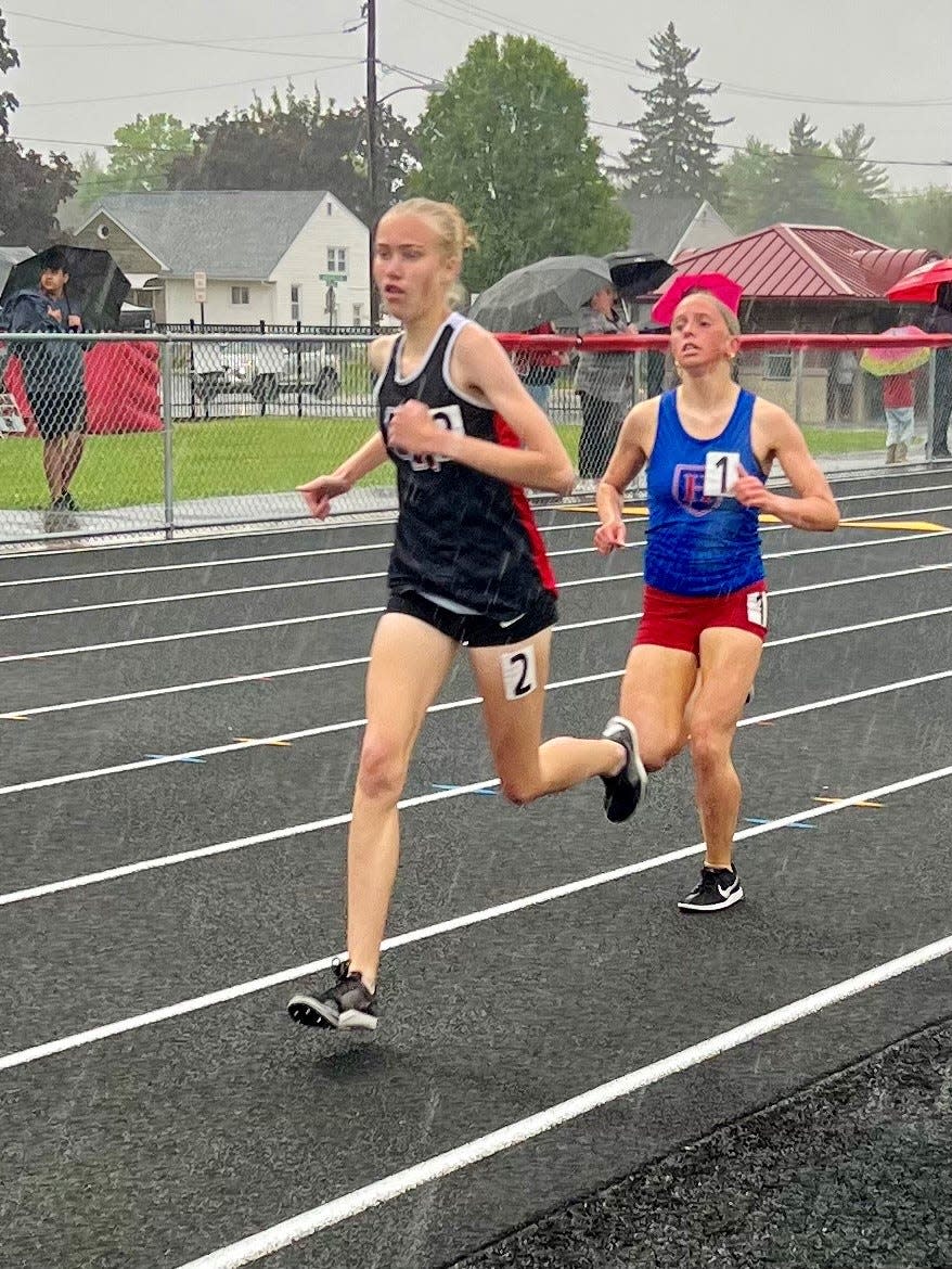 Marion Harding's Lydia Price leads Highland's Camryn Miller during the girls 1600-meter race in the rain at Harding Stadium during the Mid Ohio Athletic Conference Track and Field Championships on Thursday.